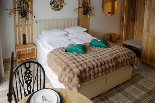 una camera da letto con un letto con due cuscini verdi di Wiślański Renifer a Wisła