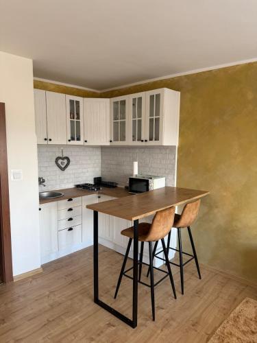 a kitchen with white cabinets and a wooden table at Golden Central Studio in Martin