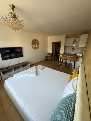 a bedroom with a large white bed and a kitchen at Golden Central Studio in Martin