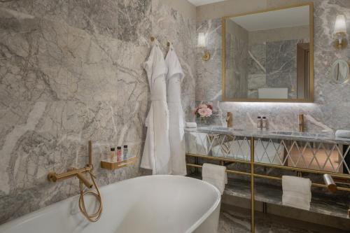 a bathroom with a tub and a sink and a mirror at Gabrielli Luxury Apartments Venezia - Starhotels Collezione in Venice