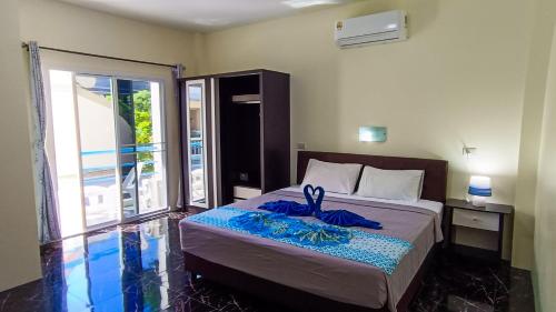 ein Schlafzimmer mit einem Bett und einem Balkon in der Unterkunft Kata Lina guesthouse in Kata Beach