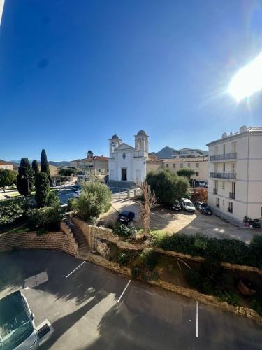 Blick auf einen Parkplatz mit einem Gebäude in der Unterkunft Apartment 2 steps from Ile-Rousse Beach in LʼÎle-Rousse