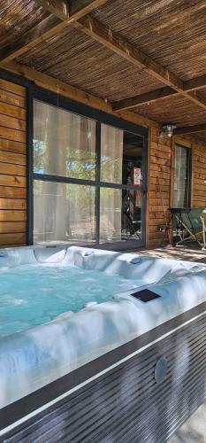 una grande vasca idromassaggio situata all'interno di una casa di Chalet au bois tranquille a Saint-André-de-Double