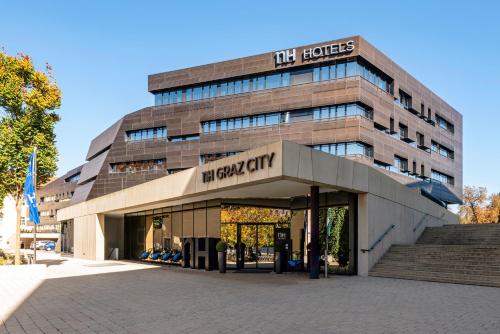 a building with a sign on the front of it at NH Graz City in Graz