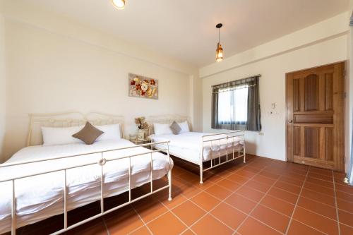 a bedroom with two beds and a window at 宜蘭閑居民宿 in Suao