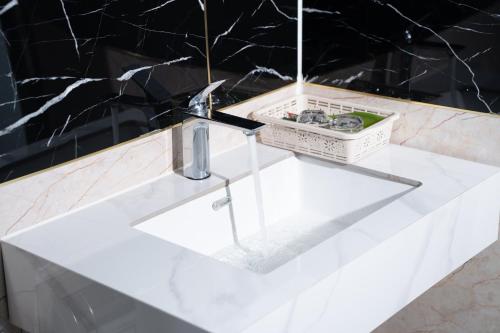 un lavandino bianco in un bagno con parete nera di Tamcoc De Master Lux Bungalow & Villa a Ninh Binh