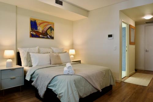 a bedroom with a bed with a stuffed animal on it at Modern Barangaroo Apartment with Waterfront Balcony Views & Private Parking in Sydney