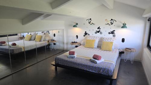 a bedroom with two beds and a wall with motorcycles on it at Appart'hotel Fior Di Ribba in Sartène