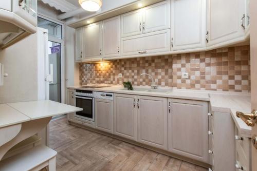 a kitchen with white cabinets and a sink at MainAvenue White Tower in Thessaloniki