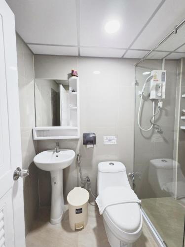 a small bathroom with a toilet and a sink at PT Grand Hotel in Ban Tha Makham