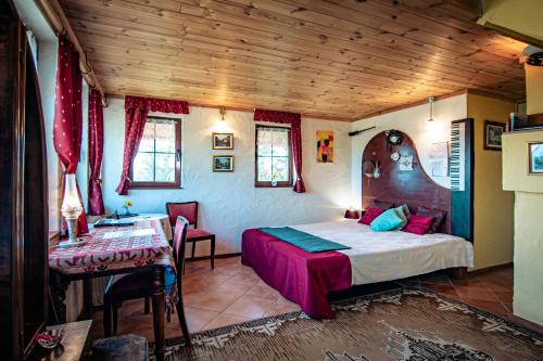 a bedroom with a bed and a table in a room at Varsádi Birtok Piano in Somlóvásárhely
