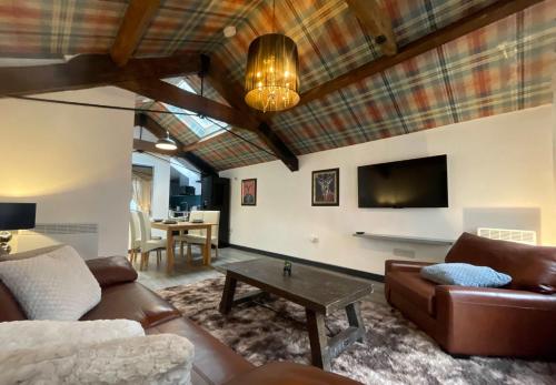 a living room with a couch and a tv at Balmoral Lodge, King Size Apartment by The Hive WA1 in Warrington