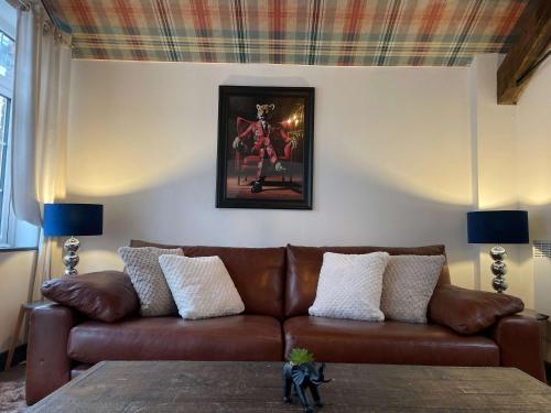 Balmoral Lodge, King Size Apartment by The Hive WA1 في وارينغتون: غرفة معيشة مع أريكة جلدية بنية اللون