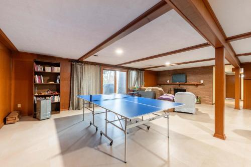 a blue ping pong table in a living room at Spacious 4BR Home with BBQ Yard Near Golf Course in Rockford