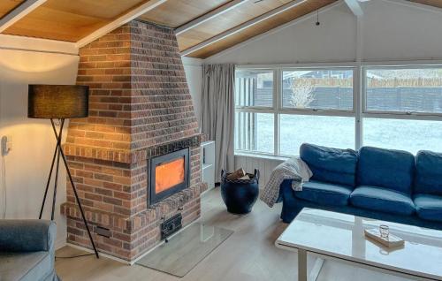 a living room with a couch and a brick fireplace at 3 Bedroom Cozy Home In Korsør in Tjæreby
