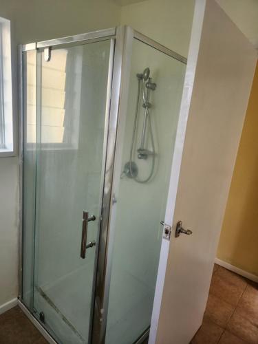 a shower with a glass door in a bathroom at Guest House Tokoroa in Tokoroa