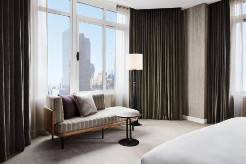 Pokój hotelowy z krzesłem i dużym oknem w obiekcie The Luxury Collection Hotel Manhattan Midtown w Nowym Jorku