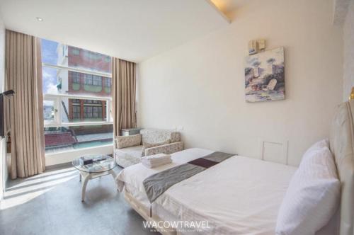 a bedroom with a bed and a chair and a window at 萊家莉民宿 in Xiaoliuqiu