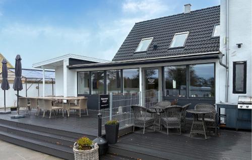 a wooden deck with a table and chairs on it at 7 Bedroom Stunning Home In Samsø in Kolby Kås