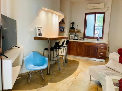 a kitchen with a table and chairs in a room at Elinor's Secret Suite in Sulam Tsor