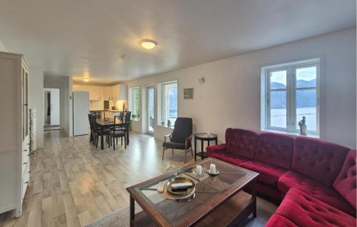 Una sala de estar con un sofá rojo y una mesa. en Amazing Apartment In Forsand With House Sea View, en Helle