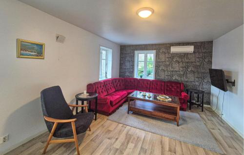 Una sala de estar con un sofá rojo y una mesa. en Amazing Apartment In Forsand With House Sea View, en Helle