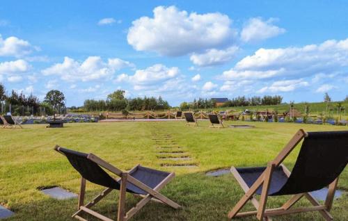 a group of lawn chairs sitting in a field at Cozy Home In Sianowo With Wifi in Sianowo