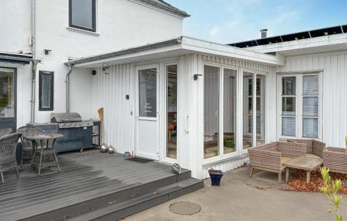 a white house with a deck with a grill at 1 Bedroom Beautiful Home In Samsø in Kolby Kås