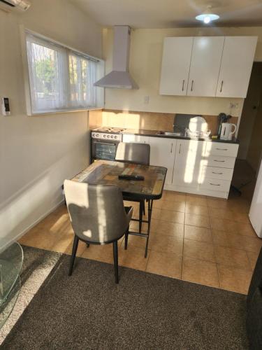 a kitchen with a table and chairs in a kitchen at Guest House Tokoroa in Tokoroa