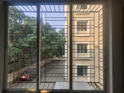 a window view of a building with a car outside at Stay Place in kolkata