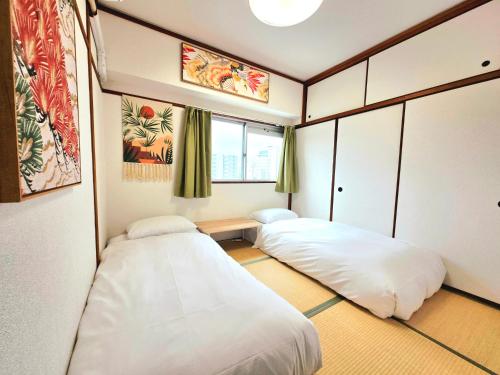 a room with two beds and a window at 嵐 Arashi BNB 難波西 No8112 in Osaka