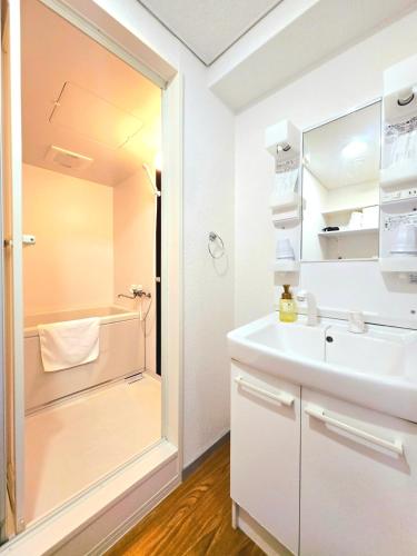 a bathroom with a sink and a shower at 嵐 Arashi BNB 難波西 No8112 in Osaka