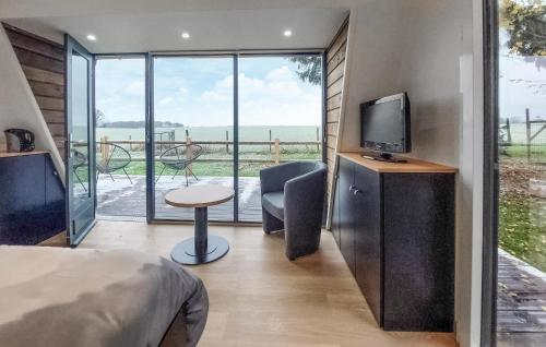 Un dormitorio con una cama y un televisor y un balcón. en Nice Home In Herry With Heated Swimming Pool, en Herry