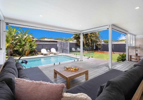 a living room with a couch and a pool at Coastal Nest - Walk to Windang Beach in Windang