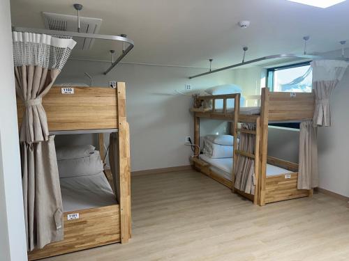 a room with two bunk beds and a window at 여주여행자센터 호스텔 in Yeoju