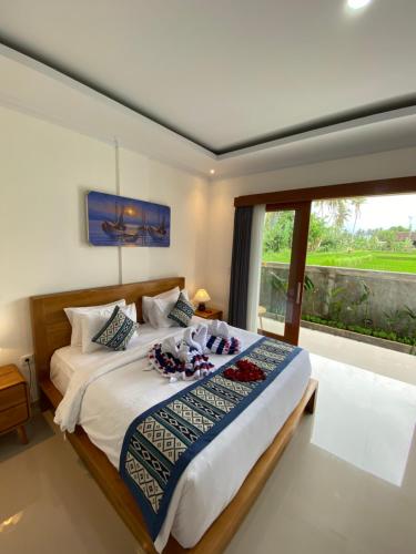 a bedroom with a large bed with a large window at Bale Sidi House in Ubud