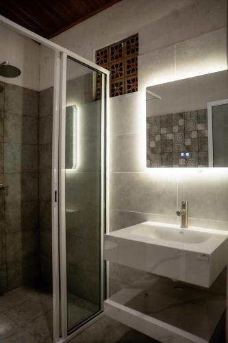 a bathroom with a sink and a glass shower at Sunsei Beach Negombo in Negombo