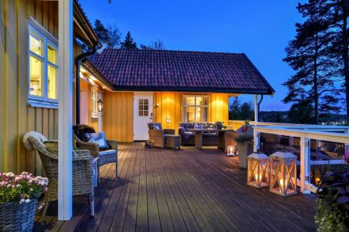 a deck with furniture and a fireplace on a house at Furuheimen - cabin by the sea in Skjeberg in Skjeberg