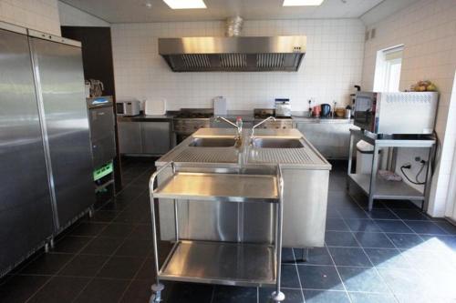 een keuken met roestvrijstalen apparatuur en een wastafel bij Group Accommodation for up to 48-persons in Wemeldinge