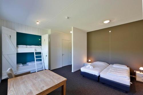 een slaapkamer met twee bedden en een tafel erin bij Group Accommodation for up to 48-persons in Wemeldinge