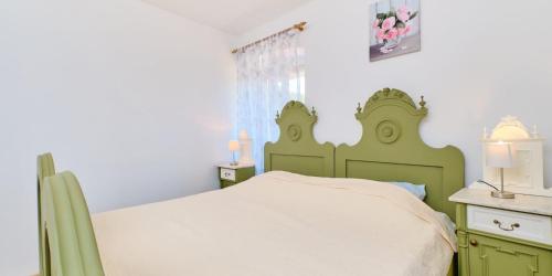 a bedroom with a green bed in a room at Pino 1 in Veli Lošinj