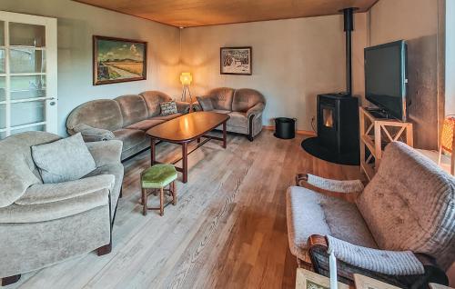 a living room with leather furniture and a flat screen tv at 3 Bedroom Beautiful Home In Hjørring in Mejeriby