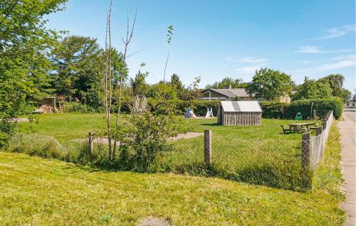 a field with a fence and a building in the background at 3 Bedroom Beautiful Home In Hjørring in Mejeriby