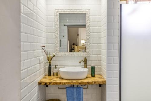 un bagno con lavandino e specchio di El Figuerar a San Juan de Palamós