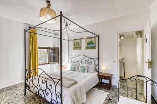 una camera con letto a baldacchino e specchio di El Figuerar a San Juan de Palamós