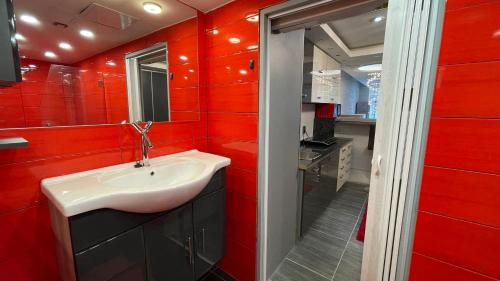 a red bathroom with a sink and a mirror at Lipno Pearl Terasa in Lipno nad Vltavou