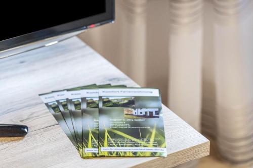 un libro seduto su un tavolo accanto a una tv di Ferienwohnung, 55qm a Herscheid
