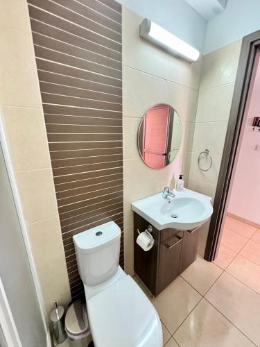 a bathroom with a toilet and a sink and a mirror at Aurora Gardens Villa Spacious 3 Bedroom in Protaras in Paralimni