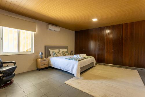 a bedroom with a bed and a chair in it at A Casa dos Amigos - Termas São Vicente in Penafiel