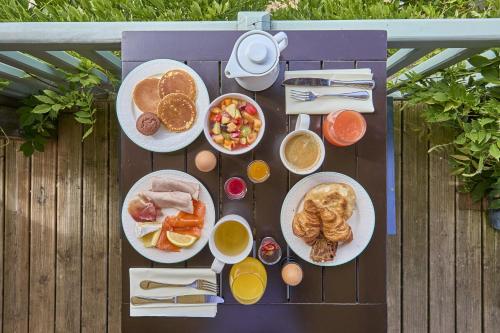 Una mesa de picnic con platos de desayuno encima. en Saint Malo Golf Resort, en Le Tronchet